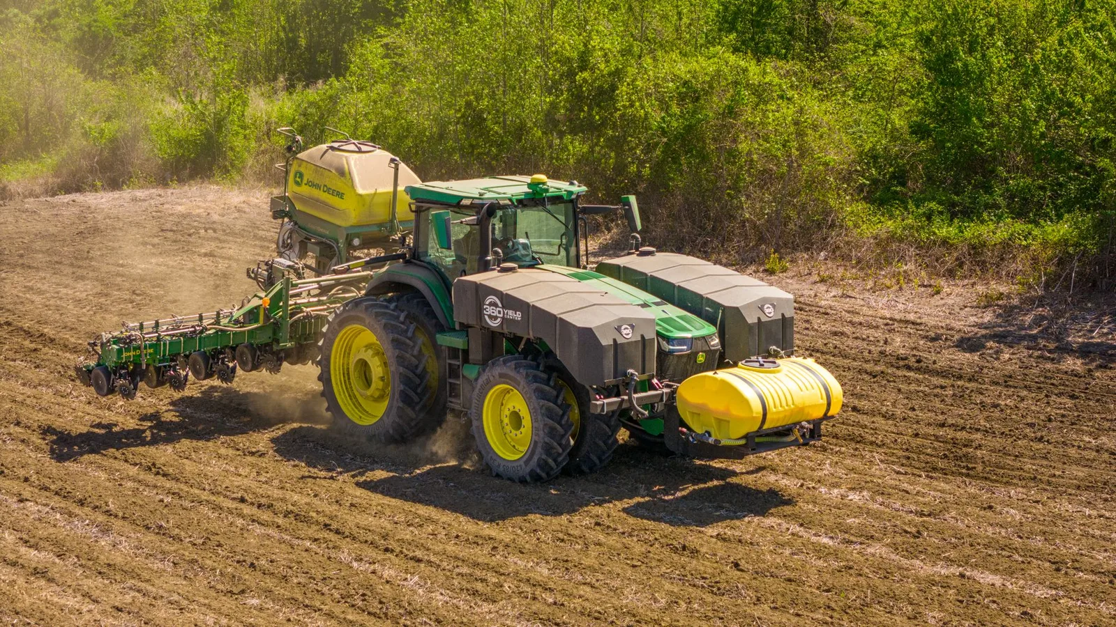 A tractor sowing seeds in a rural field on a sunny day in Prospect, NC.