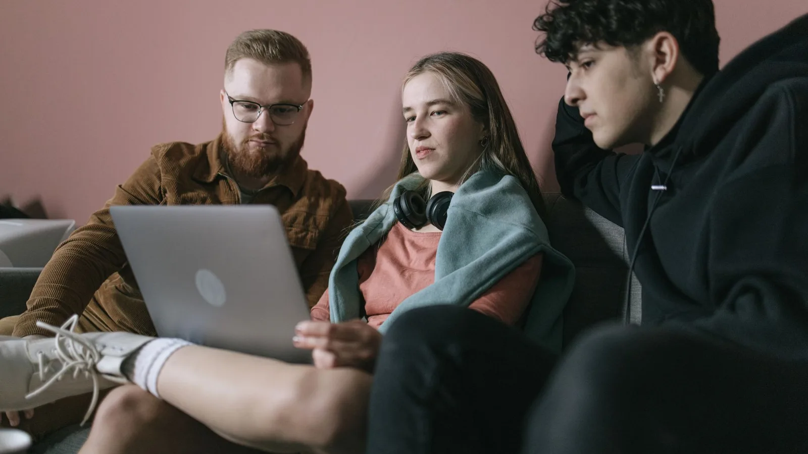 Young diverse team collaborates on a project using a laptop in an office setting.