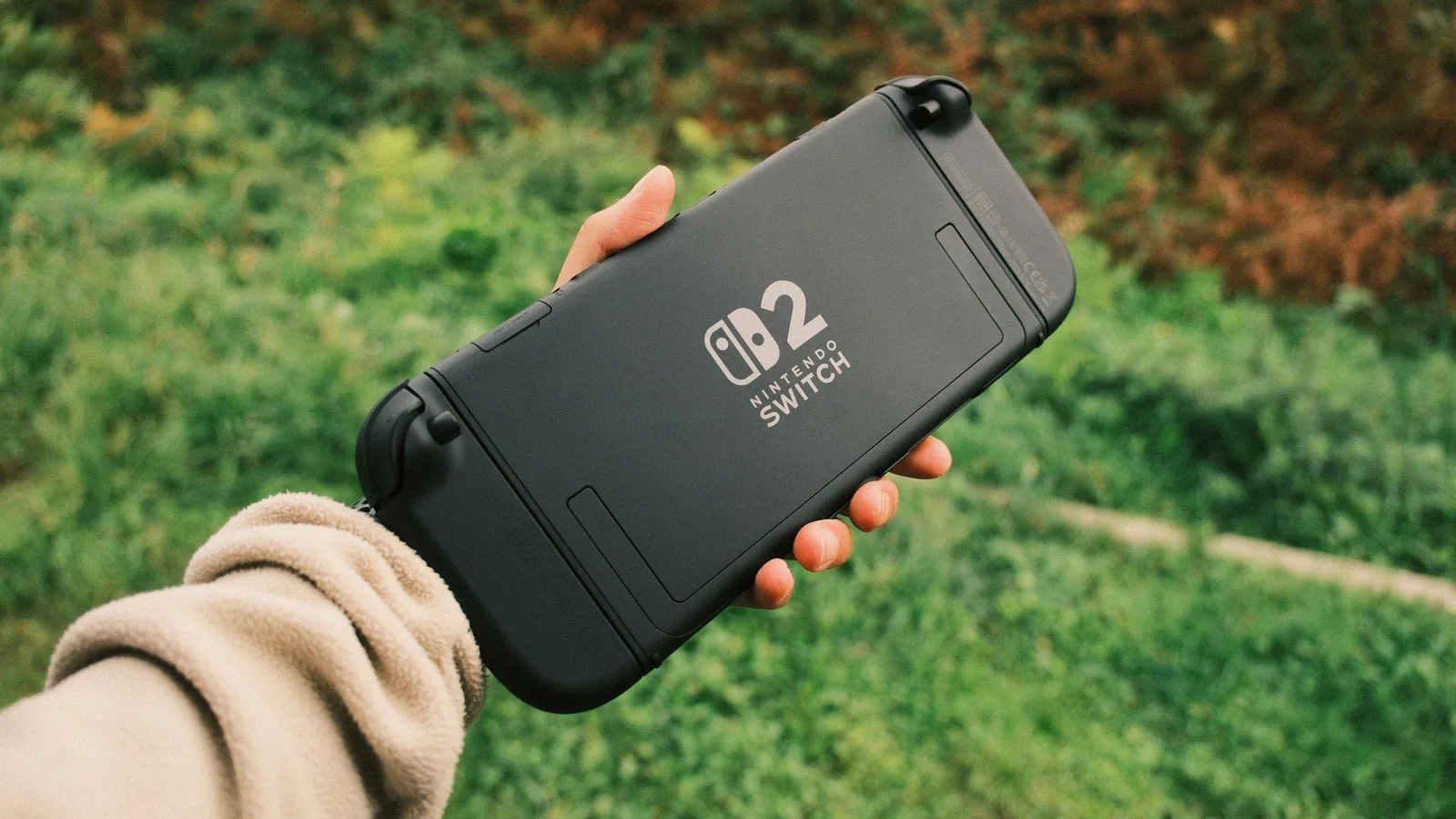 Person holding a Nintendo Switch in a natural outdoor setting, perfect for on-the-go gaming.