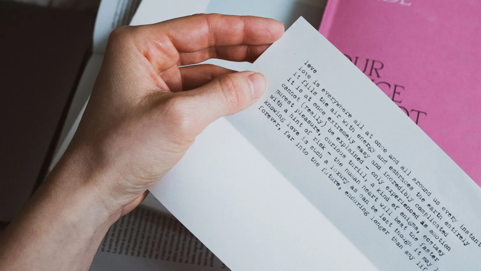 From above of crop person holding paper letter with inspirational quote in bedroom
