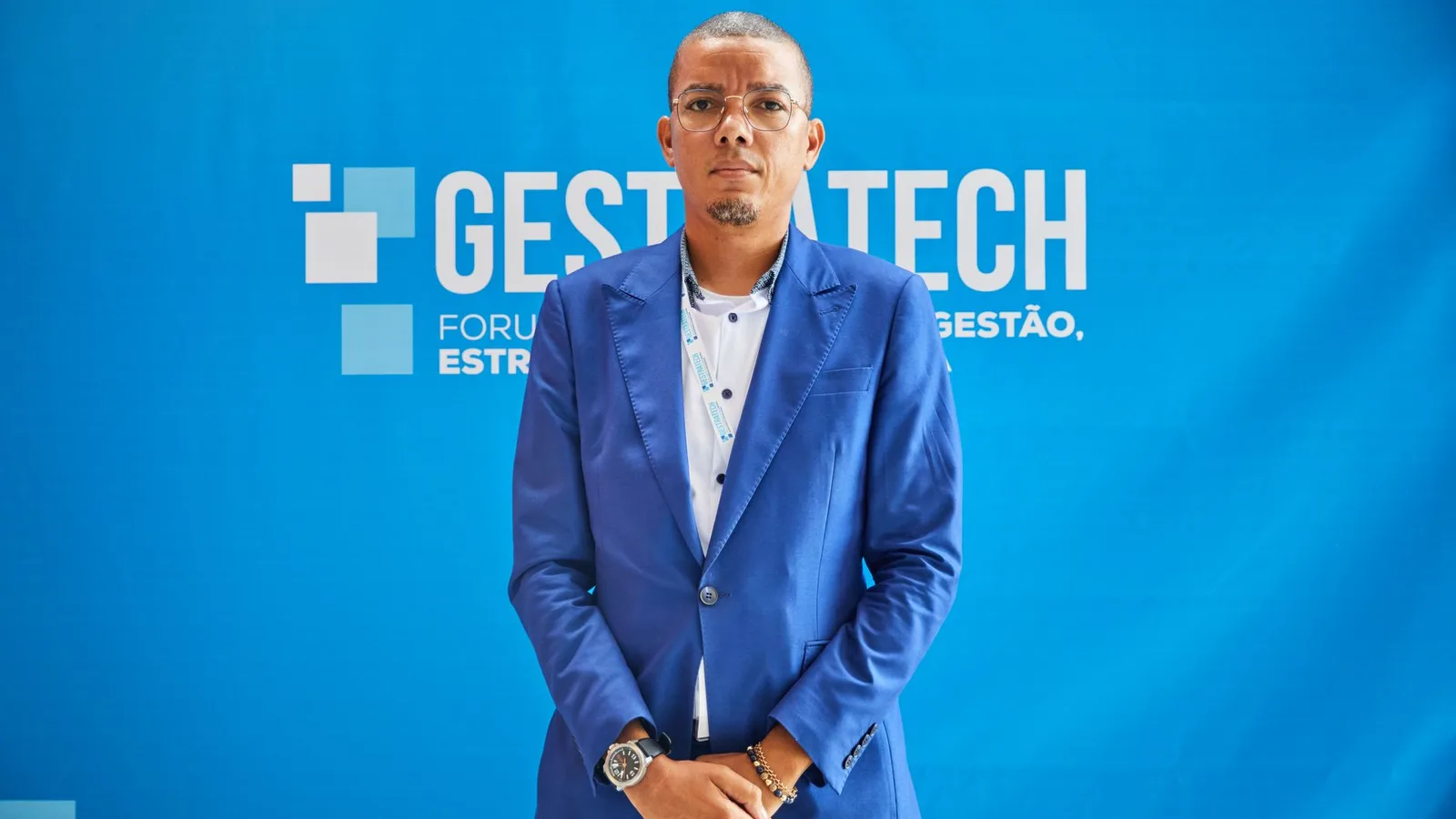 Confident businessman in blue suit at a professional conference event.